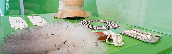 Vitrine mit Objekten in der Ausstellung "Charleston und Gleichschritt", 2020. Foto: Gustai/pi­xel­grün