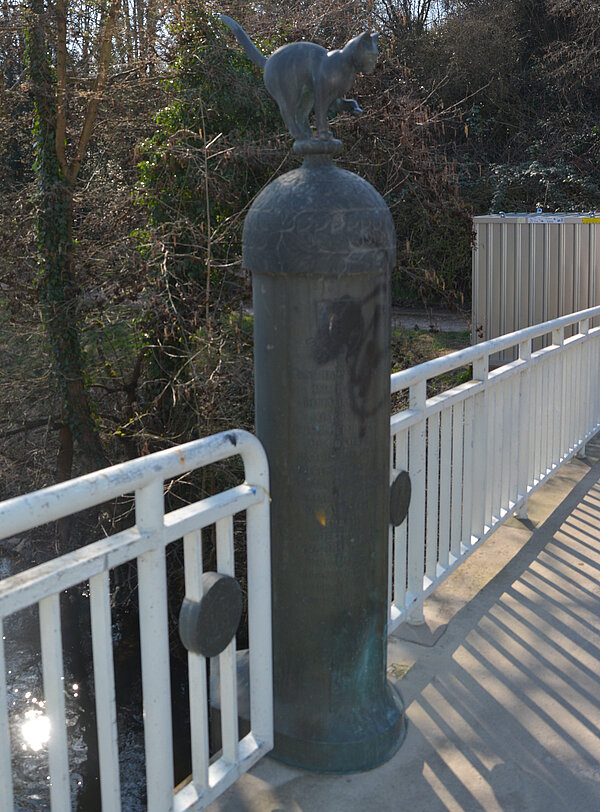 Östlicher Pylon mit Katzenfigur auf der Albbrücke vor dem "Bulicher Loch" mit Informationen zur Geschichte Beiertheims